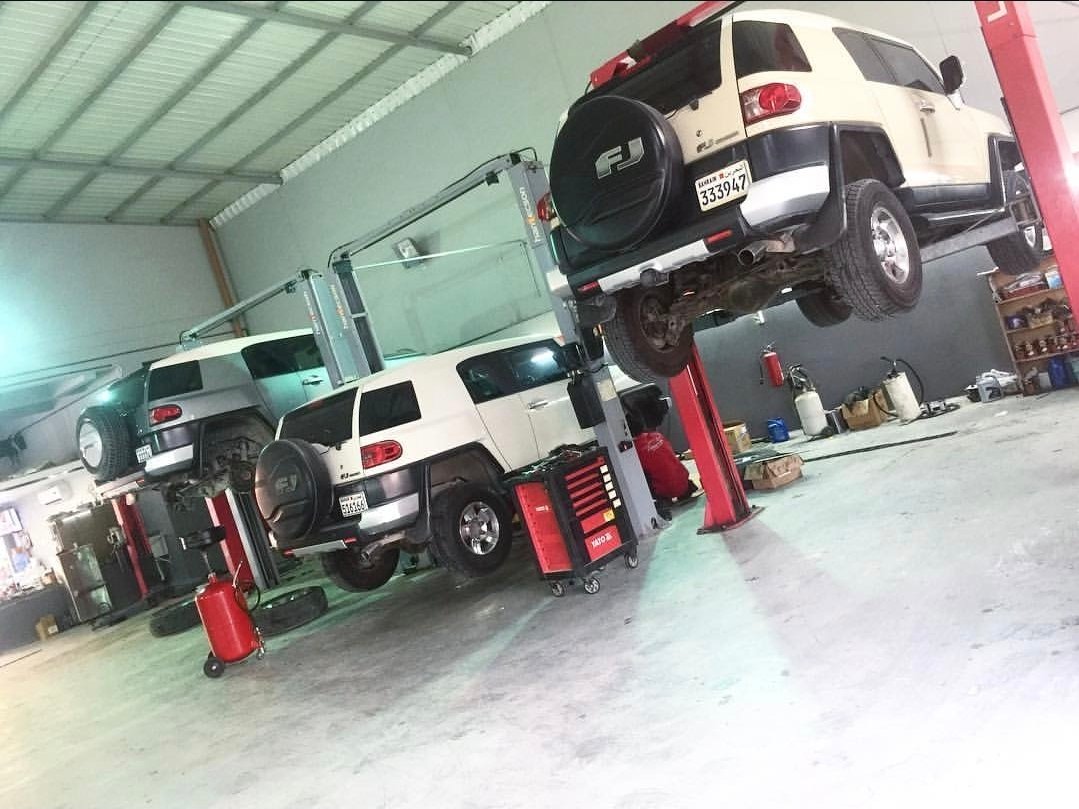 Two Toyota FJ Cruisers on workshop lifts